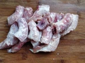 将买到的鸡脖用清水冲洗干净，再用刀刮掉表面多余的脂肪、筋膜和淋巴结、气管等杂物，用叉子扎一些小孔，然后剁成两个指节长的段。