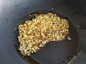 炒锅中倒入少许刚才炸鸡脖的油，烧热后爆香蒜碎、辣椒碎、孜然。