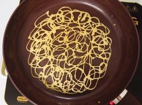 煎至一面凝固后用铲子轻轻翻面，煎至另一面凝固，趁热卷起，放凉定型即可