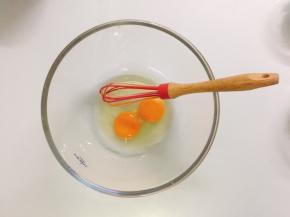 将两个鸡蛋倒入容器中，用打蛋器打散