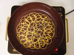 将面糊用打圈的方式随意挤入平底锅中