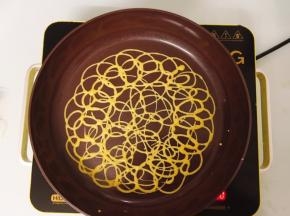 将面糊用打圈的方式随意挤入平底锅中