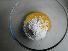 先做第1个面团，面粉平均分成两份，每份75克。把酵母溶于水里，27克蛋液倒入其中一份75克面粉里