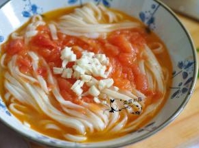 将面条捞出来，再倒入番茄高汤。最上面放上蒜粒。