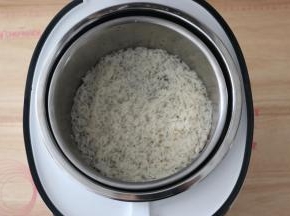 将大米放入电饭煲中。
