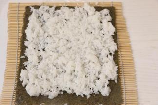 卷帘上铺一层海苔、一层米饭。