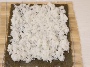 卷帘上铺一层海苔、一层米饭。