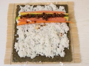 放上黄瓜条、胡萝卜条、香肠条、鸡蛋条、适量辣酱。