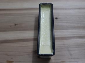 挤入模具，轻震几下，然后用刮刀将模具内的面糊整理中间低两边高。有助于最后磅蛋糕的长高和自然裂口。