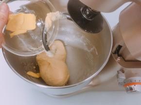 面团表面揉至表面光滑后加入软化的黄油，开低档揉至黄油完全融合于面团