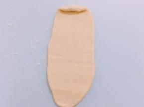 醒好的面团擀成长舌后卷成圆柱形