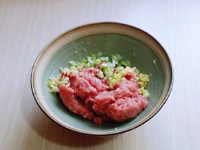 将肉糜放入器具中，加入切好的葱姜蒜。
