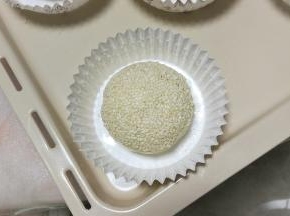 在面团表面喷层水，沾白芝麻后放纸托上，也可以直接放烤盘上，然后进行二发，发酵至两倍大。(也可以直接二发好后表面喷点水，撒一些白芝麻)