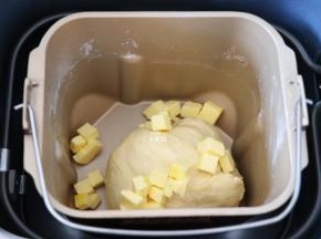 选择面包机和面程序开始揉面，揉面程序结束后放入黄油，继续选择揉面程序；