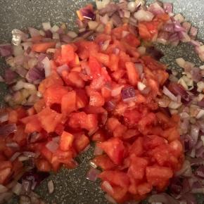 6、炒出香味后放入番茄丁，加少许盐，炒出汁(炒的时候可以用勺子压一压，方便出水）.