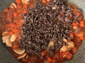9、加入牛肉末，盐，黑胡椒粉，料酒，味精调味。