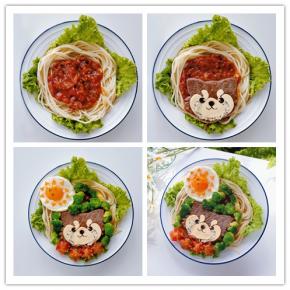 13. 组合：把煮好的意面在盘中摆成空心圆，酱汁舀在圆心处。
14. 把奶酪片和海苔图案摆在牛排上，用肉松装饰一下。
15. 将胡萝卜切成三角形小片，摆在煎蛋上，圣女果对半切开，刻出花形，和西兰花一起摆好，浣熊意面就做好了。