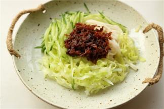 再加上切好的黄瓜丝和焯好水的圆白菜丝，再加上一勺香辣肉松酱。