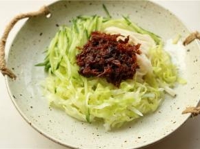 再加上切好的黄瓜丝和焯好水的圆白菜丝，再加上一勺香辣肉松酱。