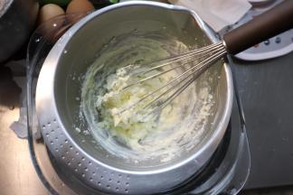 在一个大碗内倒入少许开水，再放一个打蛋盆，但是不要按到盆底，用手托住，让盆底能接触到热蒸汽，而不是直接接触热水，把黄油、奶酪和牛奶一起放入盆内。