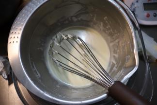 盆内的奶酪、牛奶和黄油，在下面蒸汽的热度下，让奶酪和黄油融化，用蛋抽把这三样食材混合成顺滑无颗粒的奶酪糊。