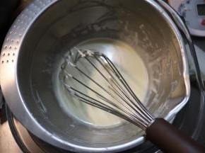 盆内的奶酪、牛奶和黄油，在下面蒸汽的热度下，让奶酪和黄油融化，用蛋抽把这三样食材混合成顺滑无颗粒的奶酪糊。
