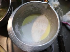 将低筋面粉和玉米淀粉混合过筛，分两次倒入奶酪糊中。