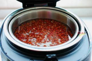 浸泡好的红小豆捞出来清洗一遍，均匀地铺在大米上。现在我们开始加水吧，因为这款臻米养生煲集煮、沥、蒸智能化一体，实现水米分离，降低大米中的含糖量，所以水量需要比普通饭煲多加一些。需要注意的是，水量不要超过大米平面1cm。