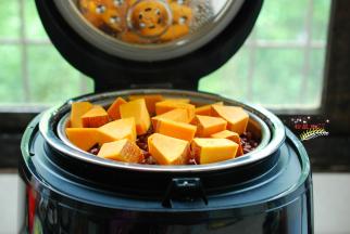 把南瓜洗净，不用去皮，切成小块，还剩下10分钟的时候，打开臻米养生饭煲的盖子，把切好的南瓜块放进去，盖上盖子，继续蒸煮。