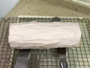 固定好的蛋糕卷上均匀抹上一层可可奶油。