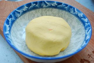 加入适量的糯米粉，揉成稍微有点硬度的面团，盖上保鲜膜，静置松弛10分钟。糯米粉也就是俗话说的江米粉，大型超市、农贸市场、网上都有卖，由于南瓜的吸水性不同，所以糯米粉的量不是固定的，先少量慢慢添加，不够再加，如果面粉添加太多了，不成团，可以再加一点点水，揉成一个稍微硬一点儿的面团就好，因为面团太软南瓜球蒸熟后容易坍塌，不成型。