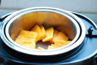 臻米脱糖养生饭煲内加入2杯清水，就用自带的量米杯就可以了。放好蒸网，切好的南瓜片放上去均匀地铺开，盖上盖子，选择“热饭”功能，12分钟。这个时间可以放心的去干别的事情了。