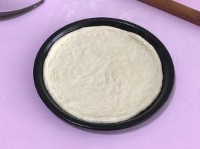 将饼皮移入披萨盘内，没有披萨盘就放烤盘里。