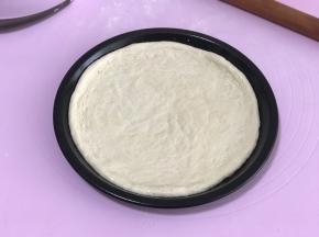 将饼皮移入披萨盘内，没有披萨盘就放烤盘里。