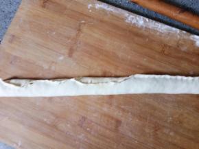 从长的一边卷起来，捏紧开口