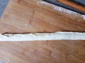 从长的一边卷起来，捏紧开口