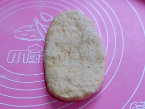 取一块面团，用擀面杖擀开，将气泡拍破。