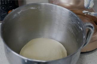 面包机二档，揉至面团微光滑，然后再加入玉米油继续揉至面与油的完全融合，面团看着舒展。