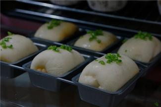 接着就要面包机发酵至面团二倍大，然后在表面刷上一层薄油，再用少入场的荞头绿部分点缀一下。提香的关键哦。