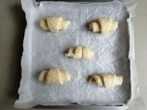 从底边开始往上卷，左右两边的半个三角形就合并在一起卷，一共做出5个羊角司康