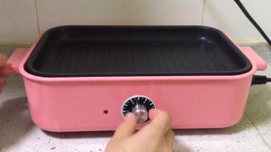 多功能锅放入坑纹烤盘，开始预热。