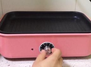 多功能锅放入坑纹烤盘，开始预热。