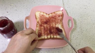 在其中一片吐司片上抹上草莓酱，或者奶油奶酪、稠质酸奶都可以。