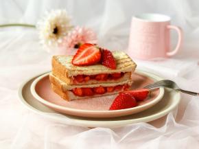 然后从中间切开，点缀上切成两半的草莓，撒上糖霜，就完成啦！特别简单哦～