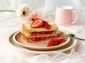 然后从中间切开，点缀上切成两半的草莓，撒上糖霜，就完成啦！特别简单哦～