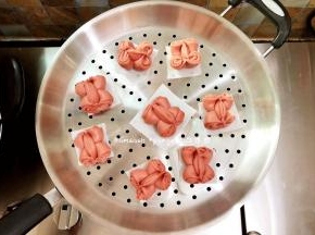 蒸锅此时可以加入水开小火微微加热，让整个锅体以及内部温热湿润，同时把做好的馒头底部垫油纸放在蒸上，放的时候要留出空间来，以免发酵的时候包子都挤在一起了，蒸锅关火，盖上锅盖发酵，发酵好的休积明显变大，拿起来轻飘飘的，就是发酵好了