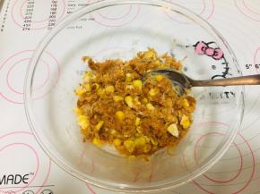 4、将肉松放入容器中，加入适量的沙拉酱，量不用太多，让肉松可以抱团即可，再加入玉米粒搅拌均匀