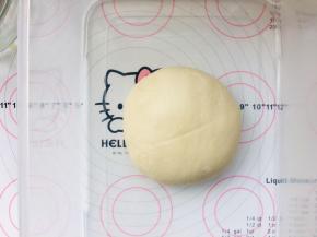 3、将面团放入到发酵盆中，轻轻压扁些，让发酵时的面团的温度尽可能的一致，表面覆盖保鲜膜进行基础发酵