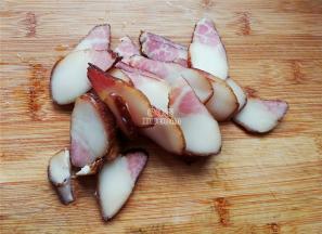 首先把烟熏腊肉用淘米水清洗掉烟熏黑，再浸泡个把小时后，切片炒菜。