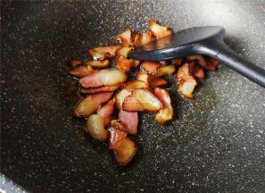 锅中倒入少许油，把腊肉片放入翻炒，煸出点油脂。